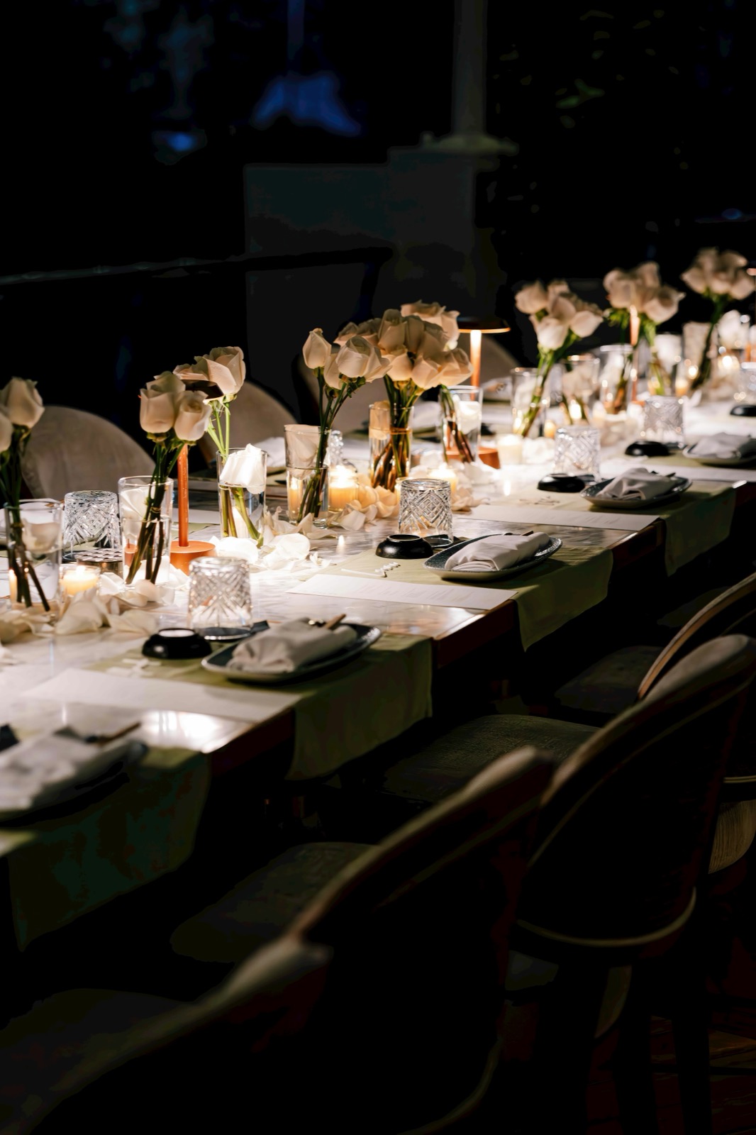Close-up of a candlelit table setting with roses